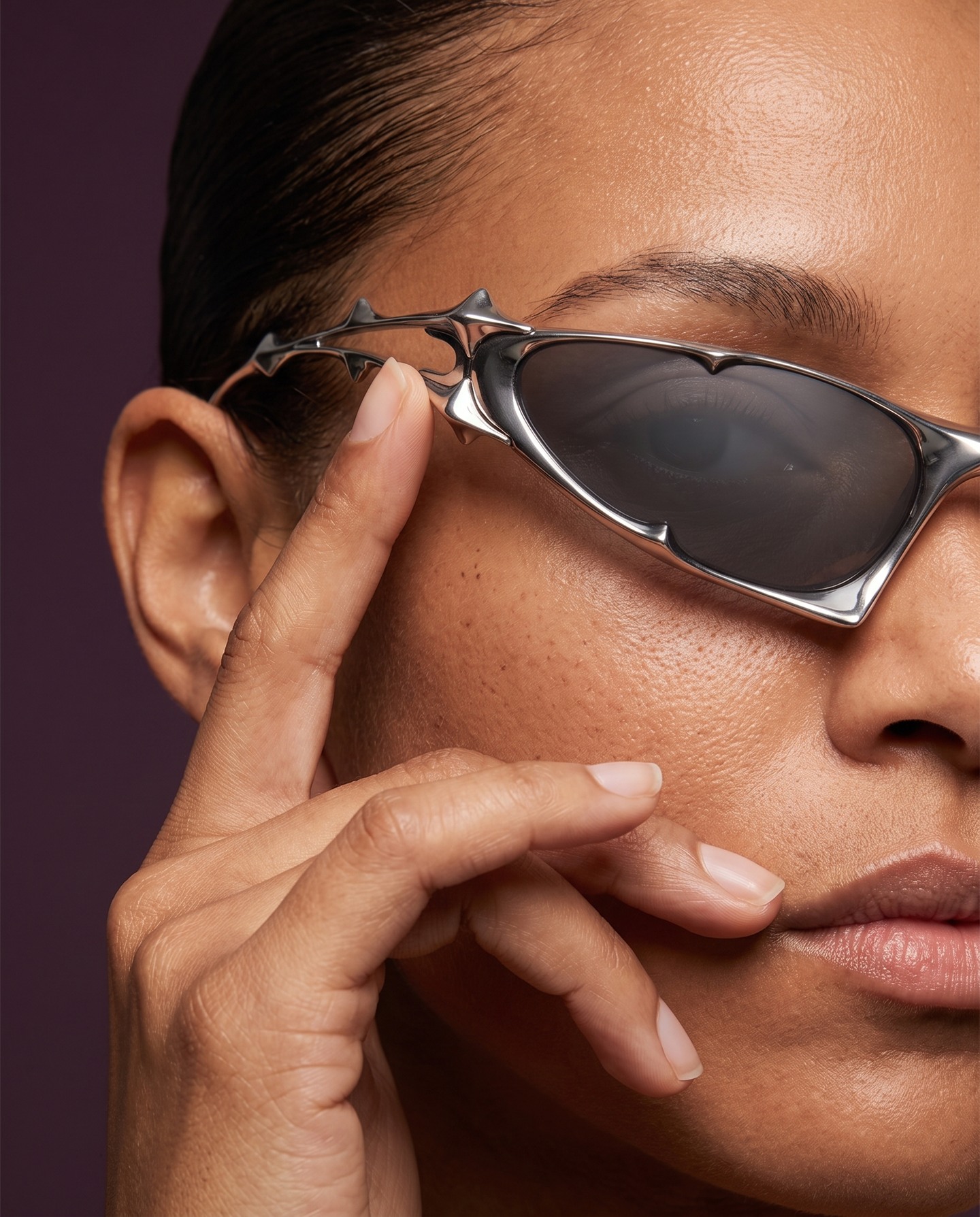 Close portrait with sculptural silver sunglasses and natural skin texture