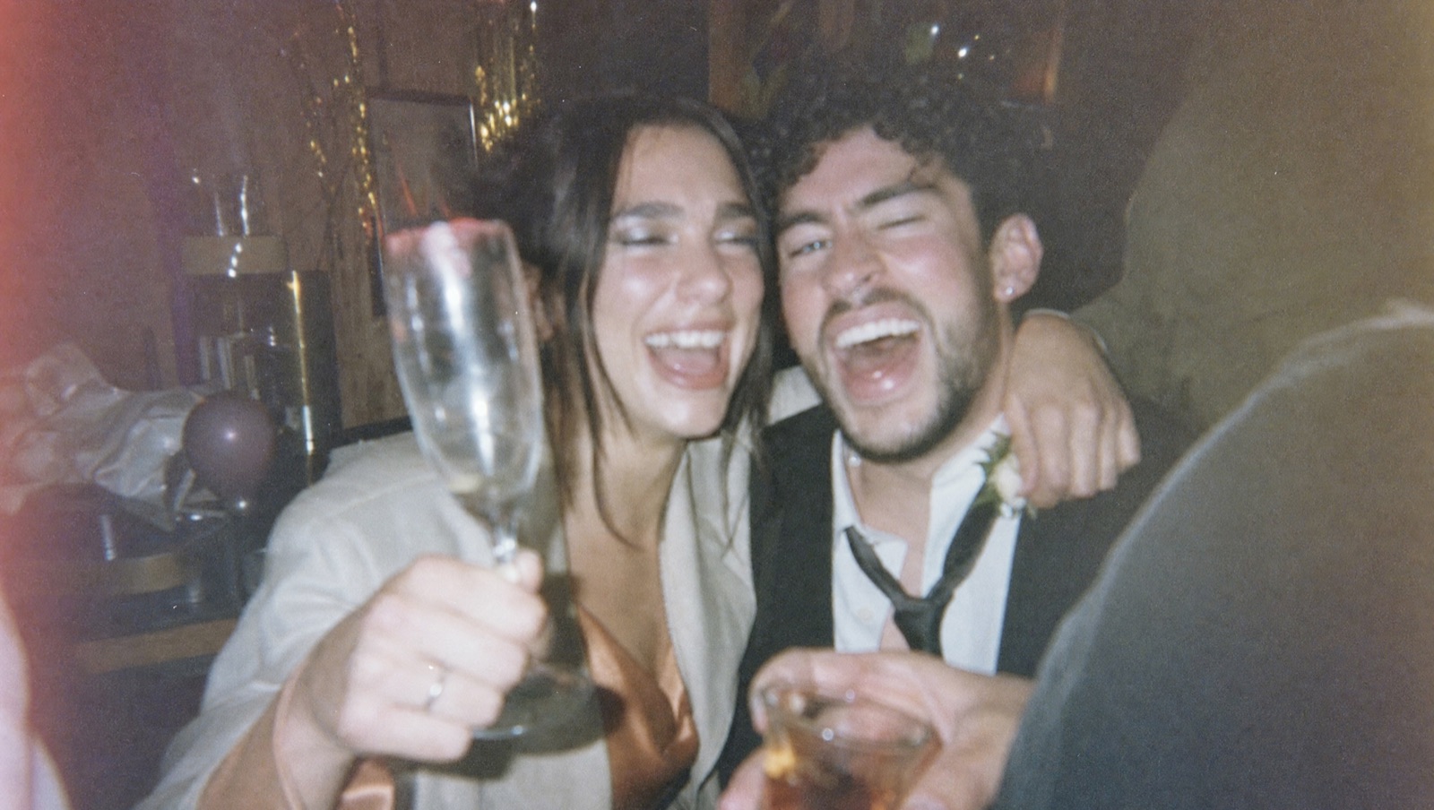 AI-generated grainy party photograph of two people laughing